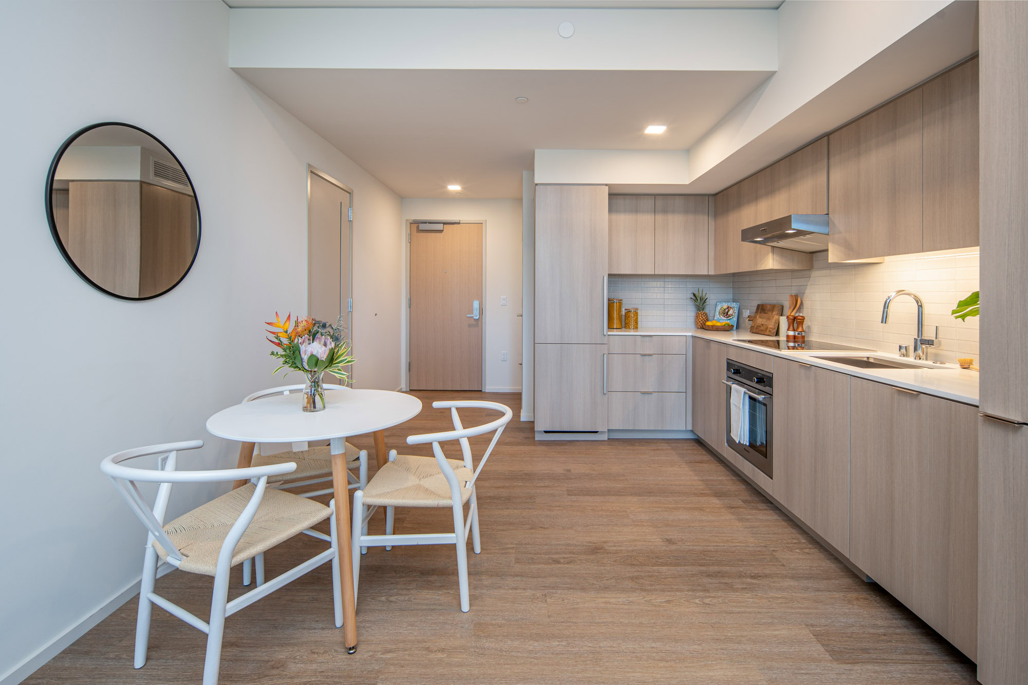 Modern kitchen with panelized appliances and dining area.
