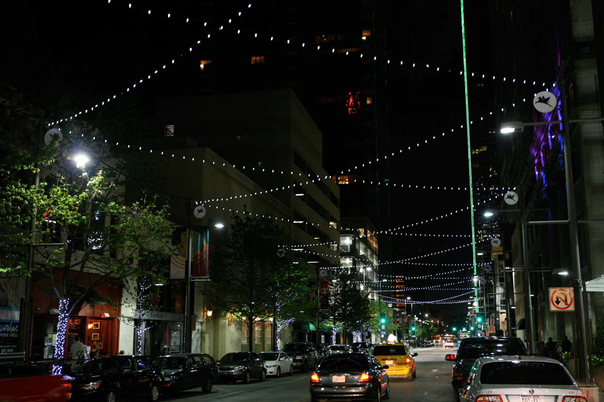 A street level view of the city in Dallas Texas with fairy lights above the street