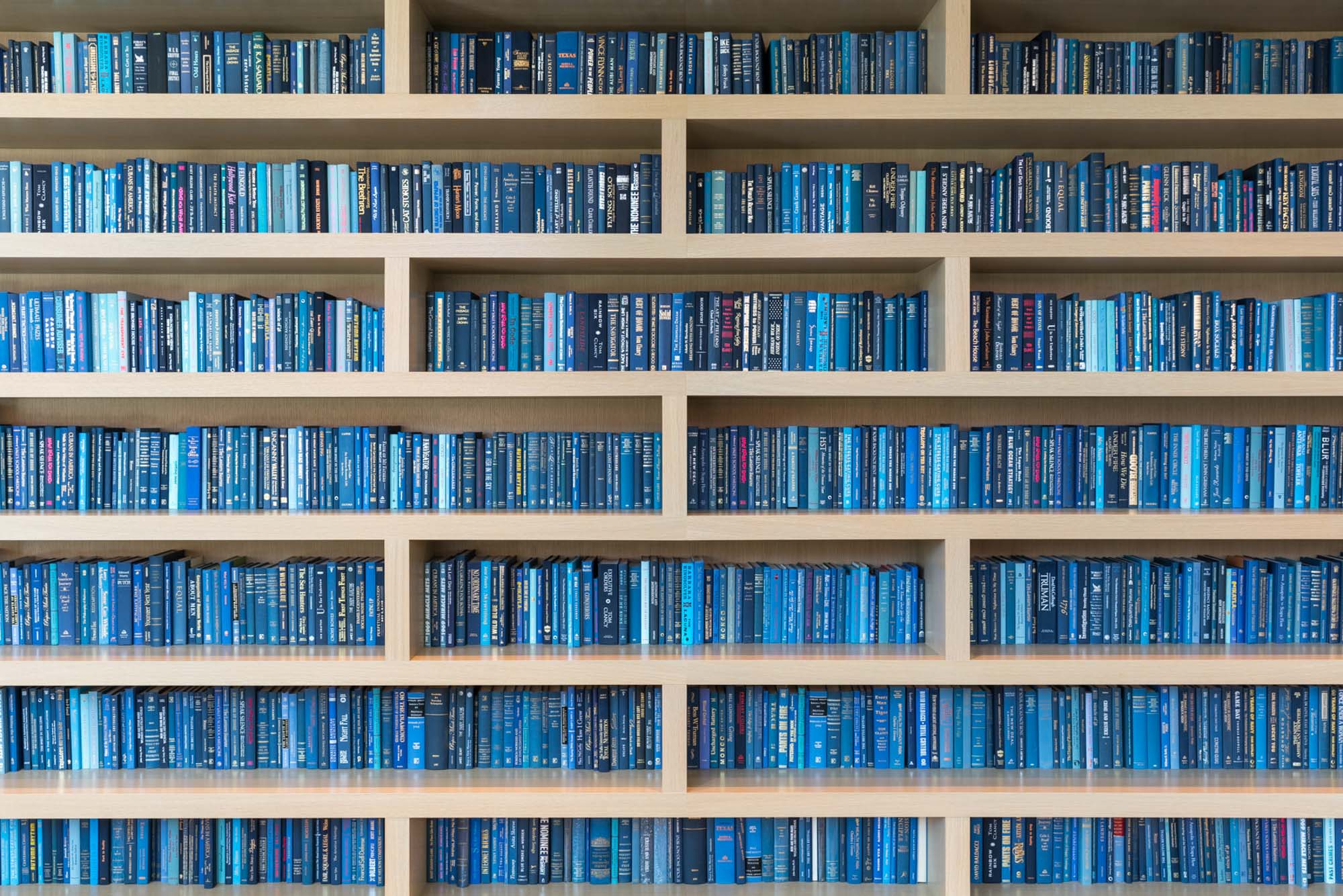 The business center bookshelf with book spines in the shade of blue at Ateliers luxury apartment in downtown LA