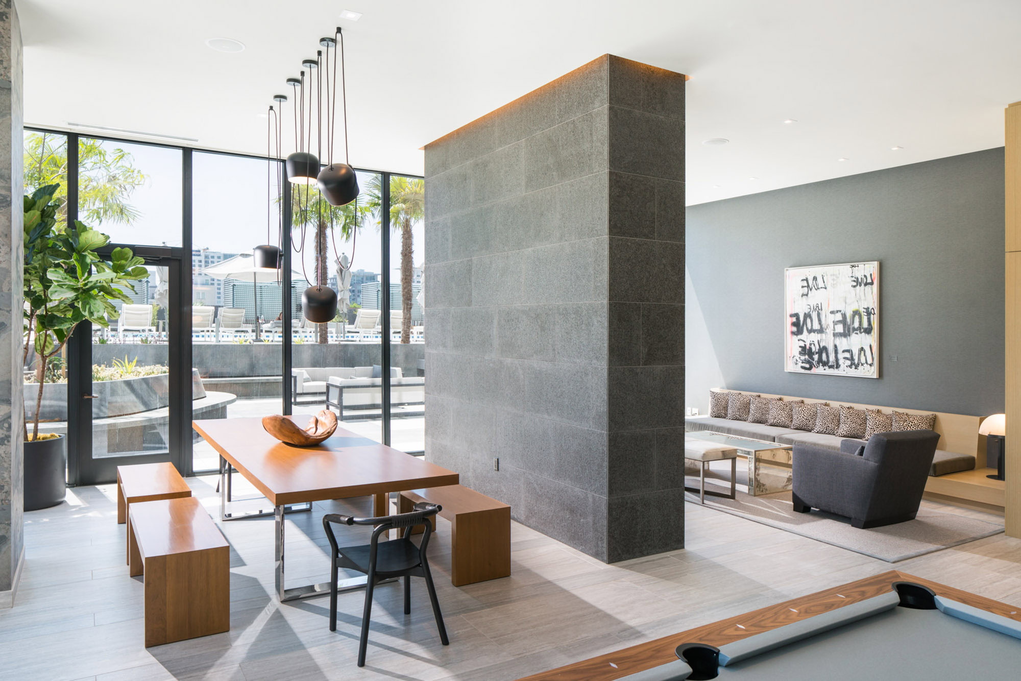 A modern clubroom with a glass door to ourdoor seating at the Ateliers luxury apartments in downtown LA