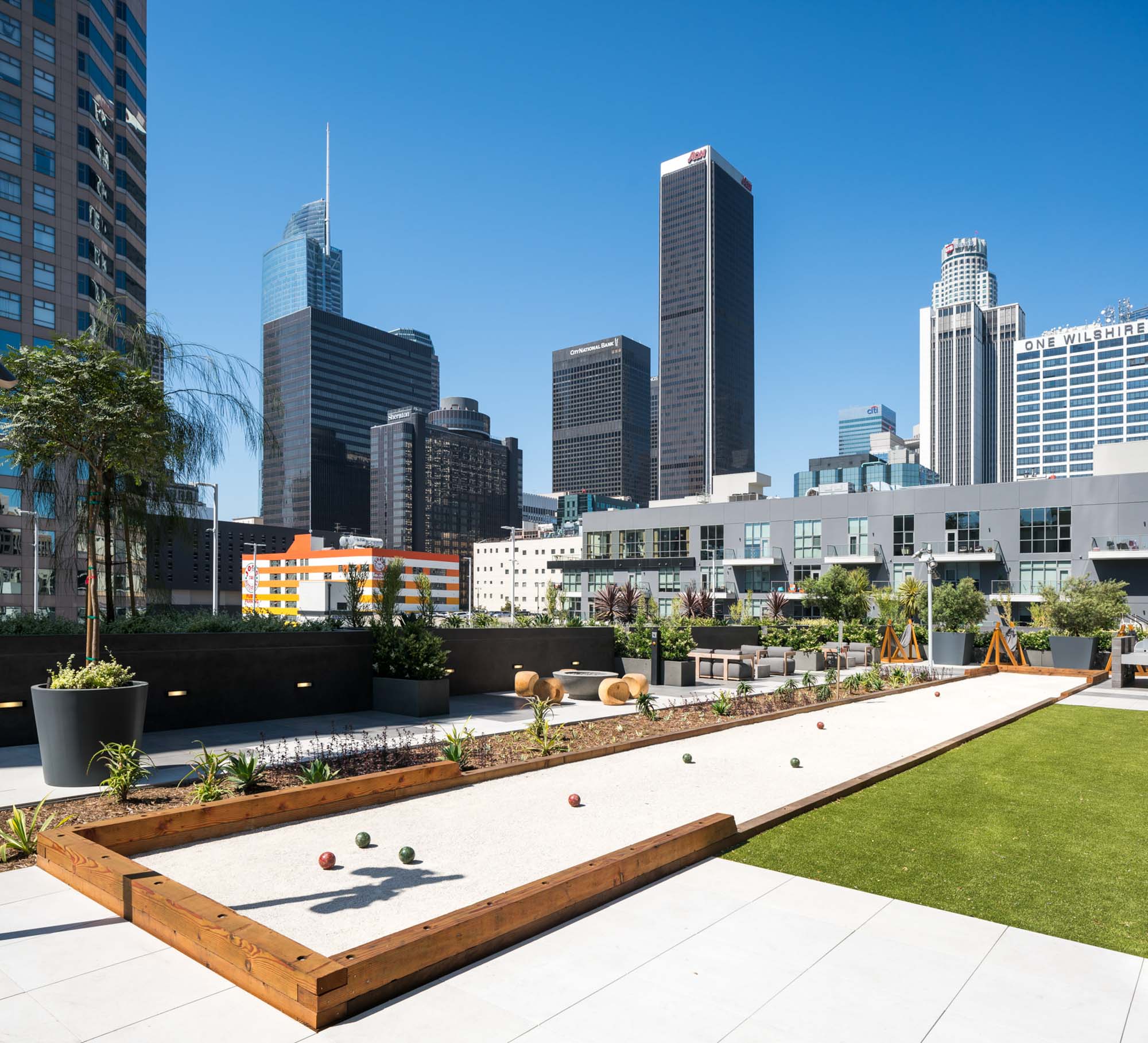 A courtyard with a bocce ball court with views of the city skyscrapers at Atelier in downtown Los Angeles