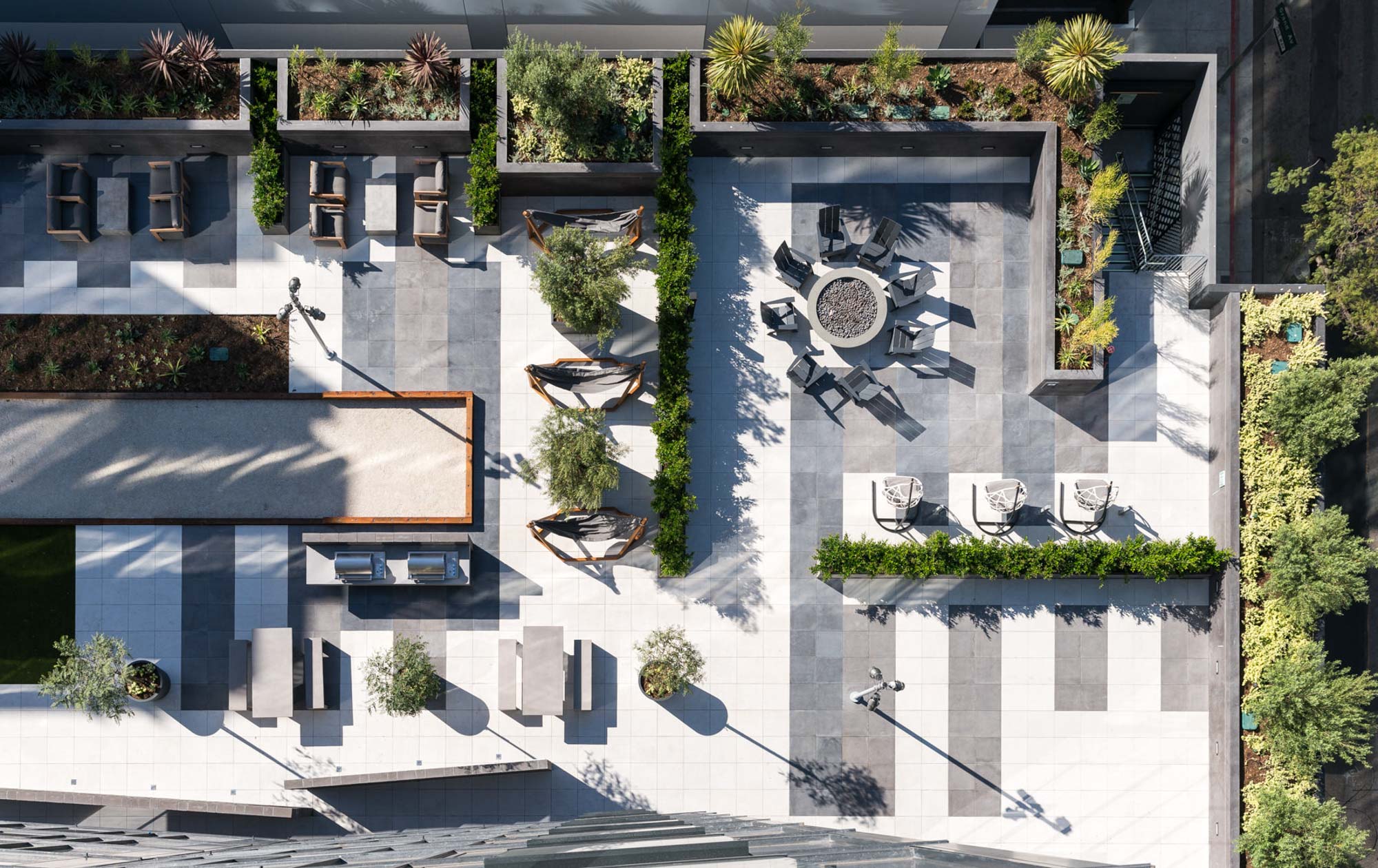 An aerial view of the courtyard showing the bocce court, hammocks, firepit and layout at Atelier apartments in downtown Los Angeles