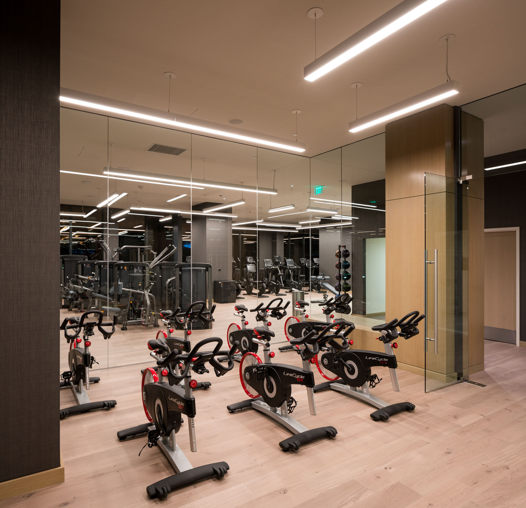 A fitness studio with a row of studio bikes in front of mirrors at the Atelier luxury apartments in downtown lost angeles