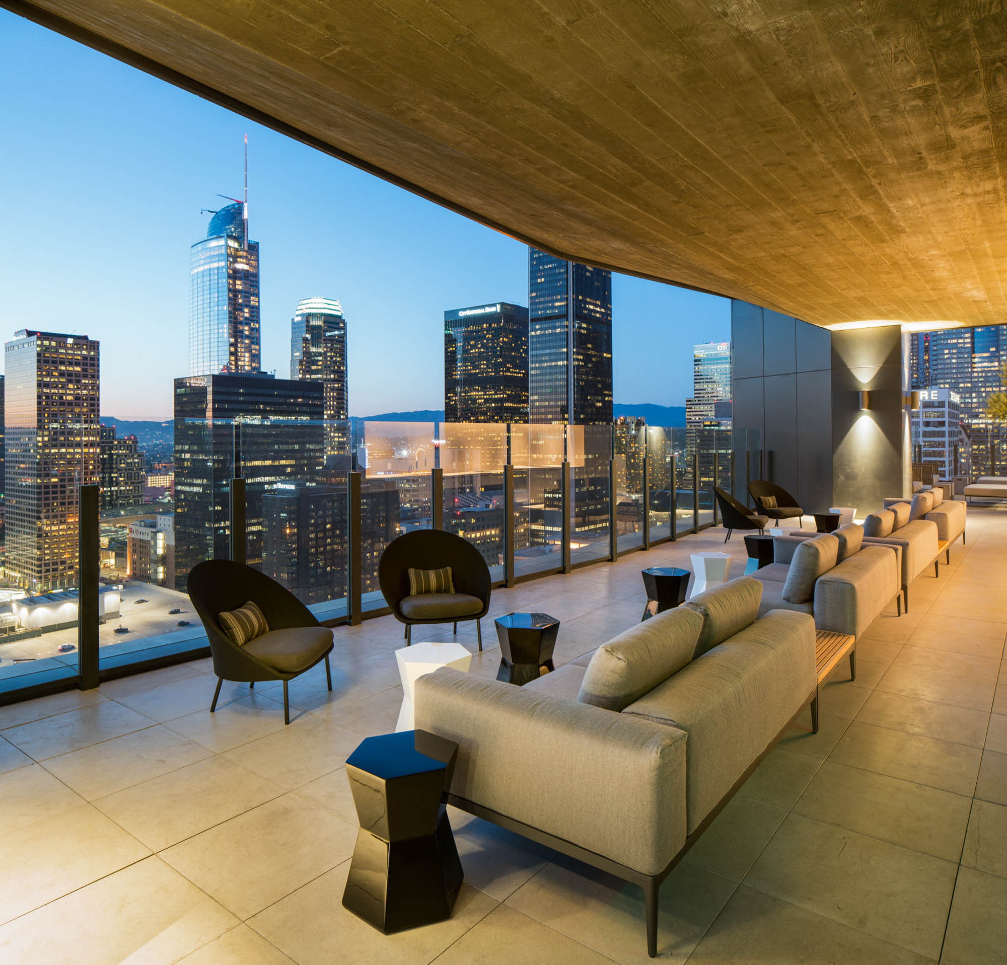 The rooftop terrace with a row of outdoor chairs and ambient lighting at Atelier apartments in downtown Los Angeles