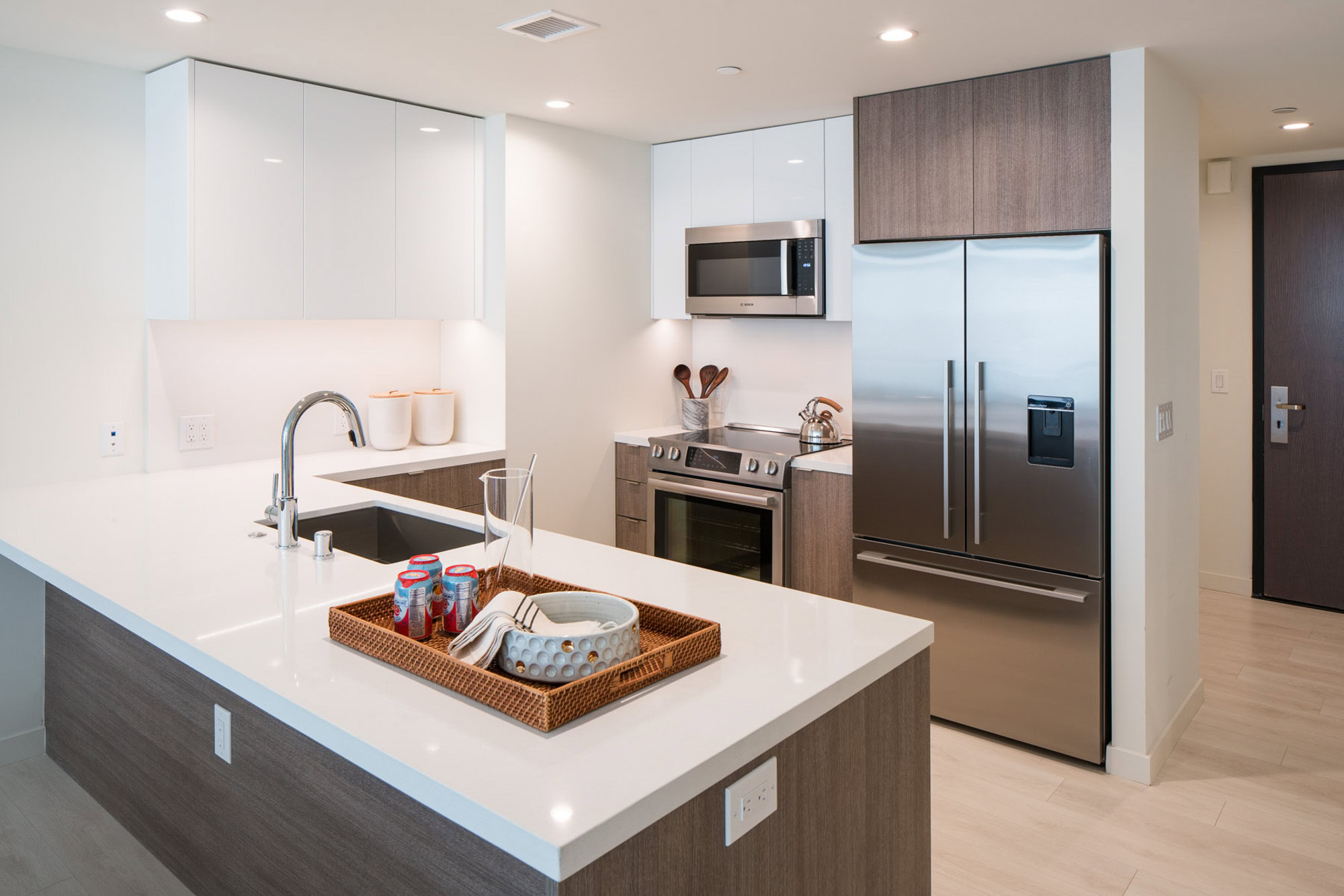A kitchen with glacier white quartz backsplash, counters, and stainless steel appliances at Atelier apartments in downtown LA