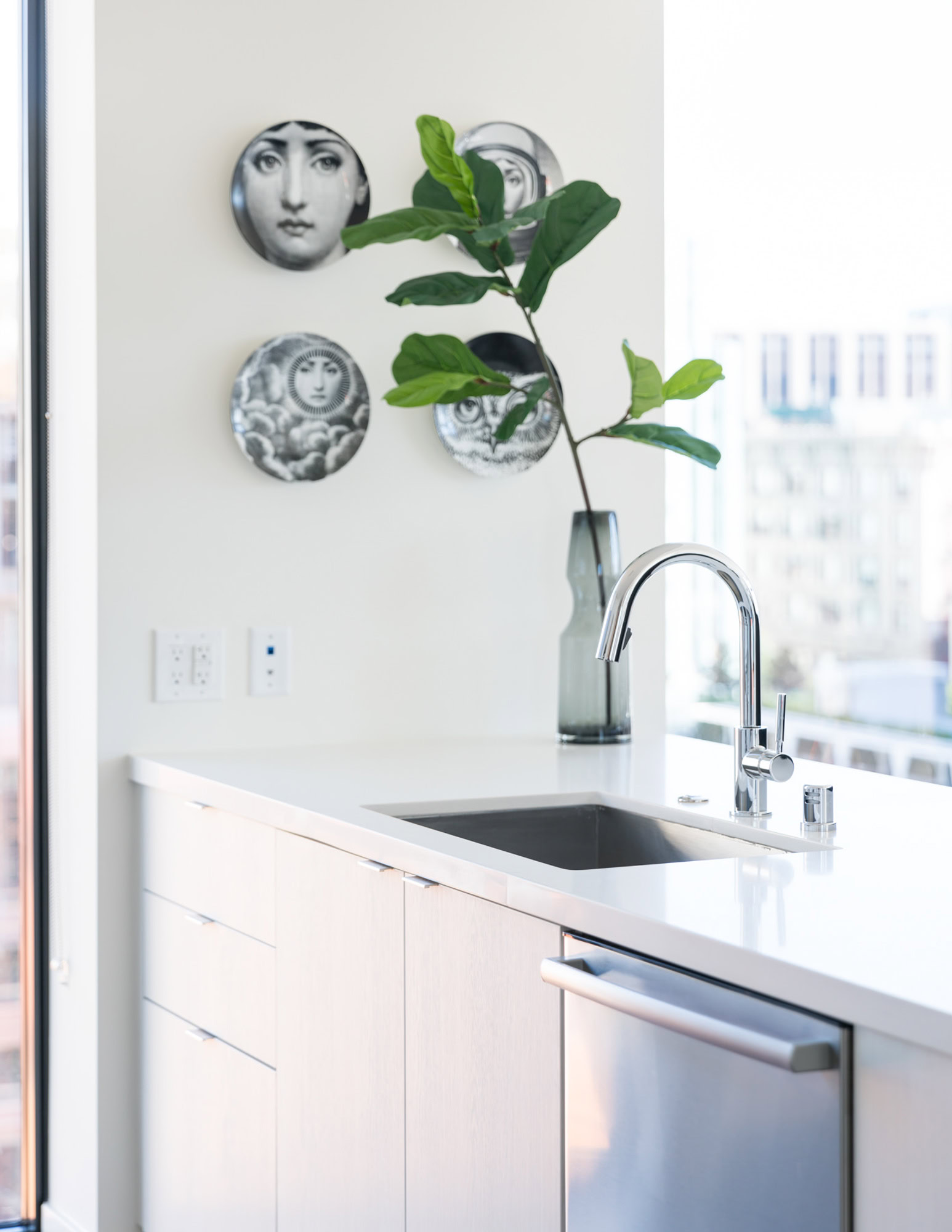 A kitchen counter with glacier white quartz countertop, and stainless appliances in Ateliers apartments in downtown LA