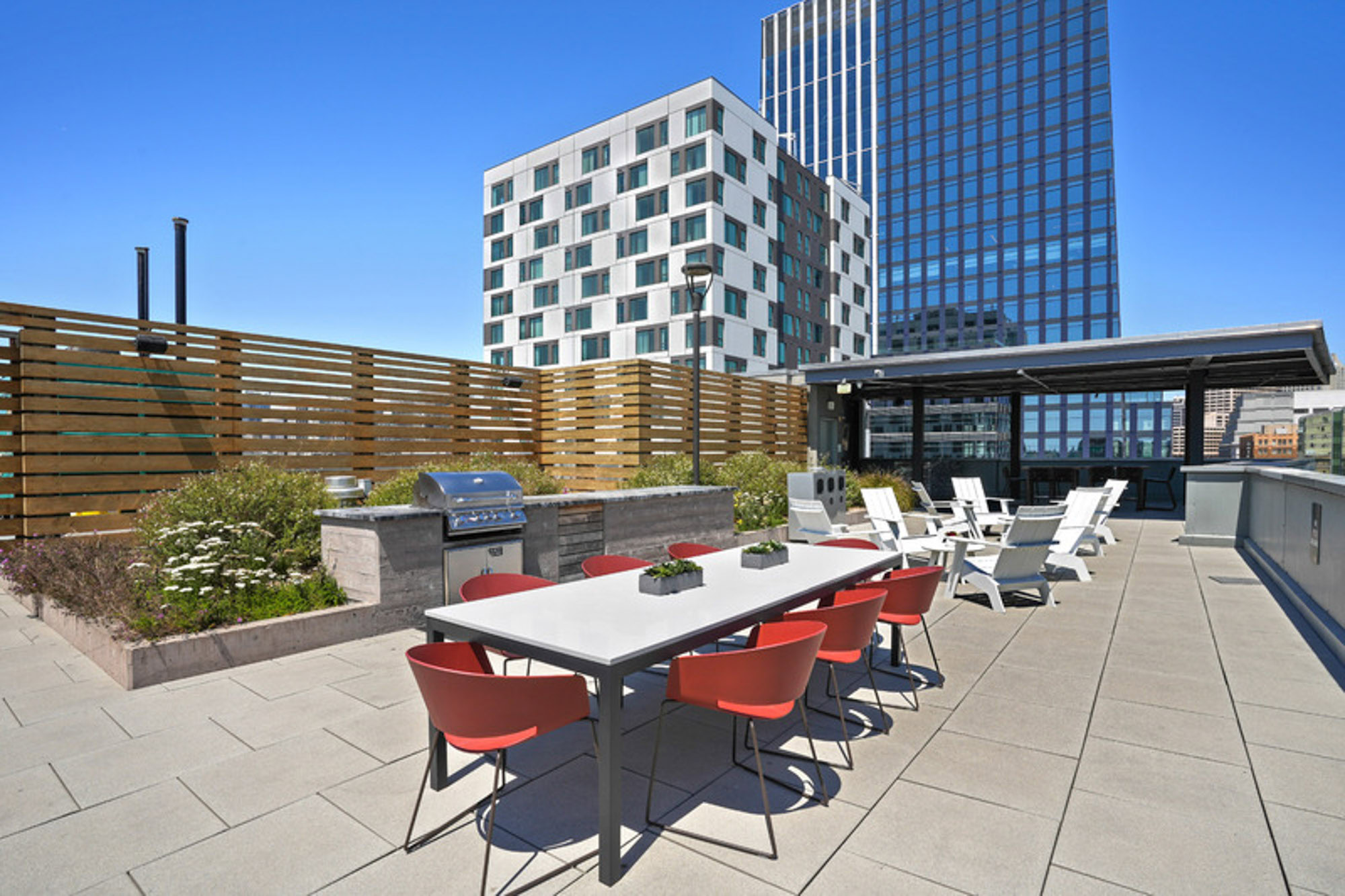 A terrace with an outdoor seating and dining tables near the outdoor grill at the Mosso apartments in downtown San Francisco