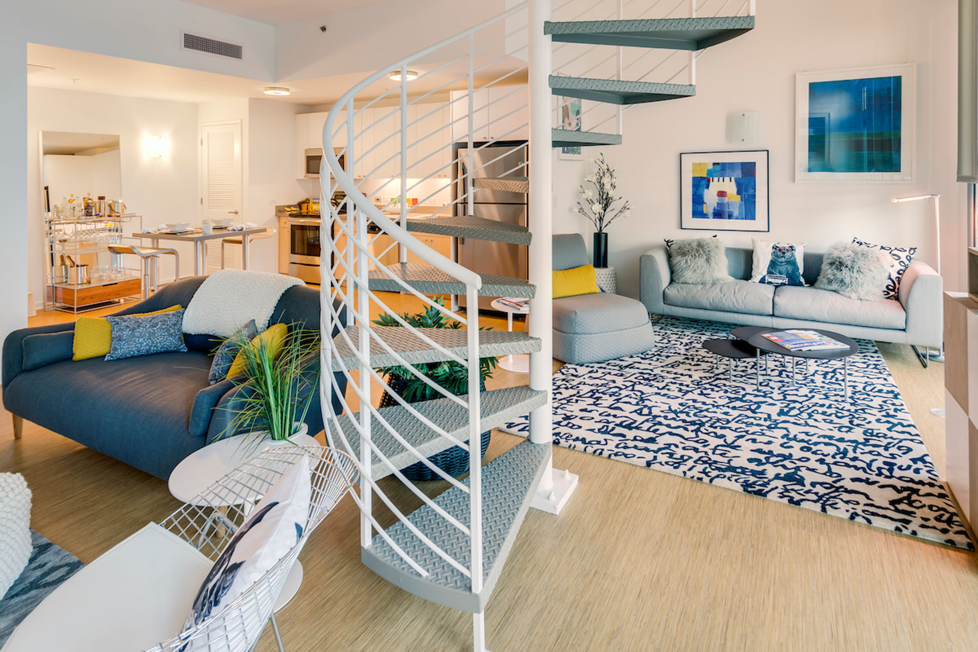 A spacious, open plan living room with a spiral staircase in the at the center at Mosso apartments in San Francisco