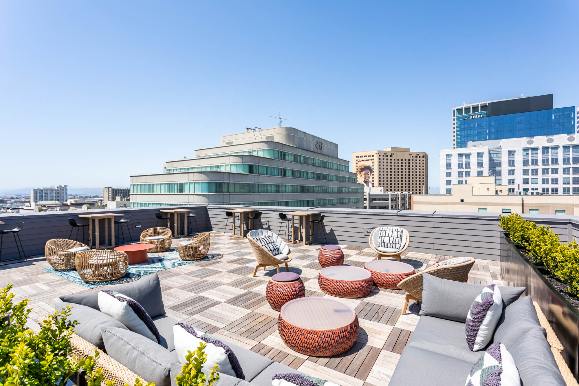 A rooftop lounge with seating and high tables and chairs at the Webster Eleven apartments in downtown Oakland