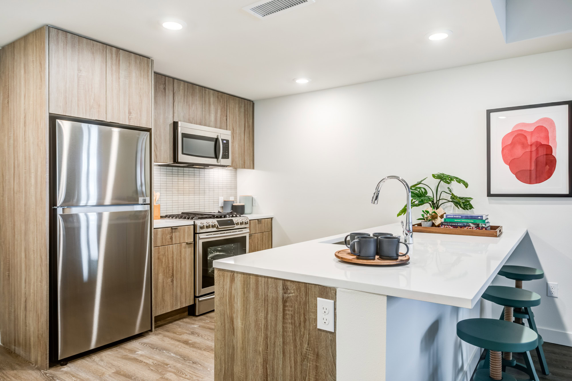 A kitchen with a peninsula and hardwood floors at the Webster Eleven downtown Oakland luxury apartments 