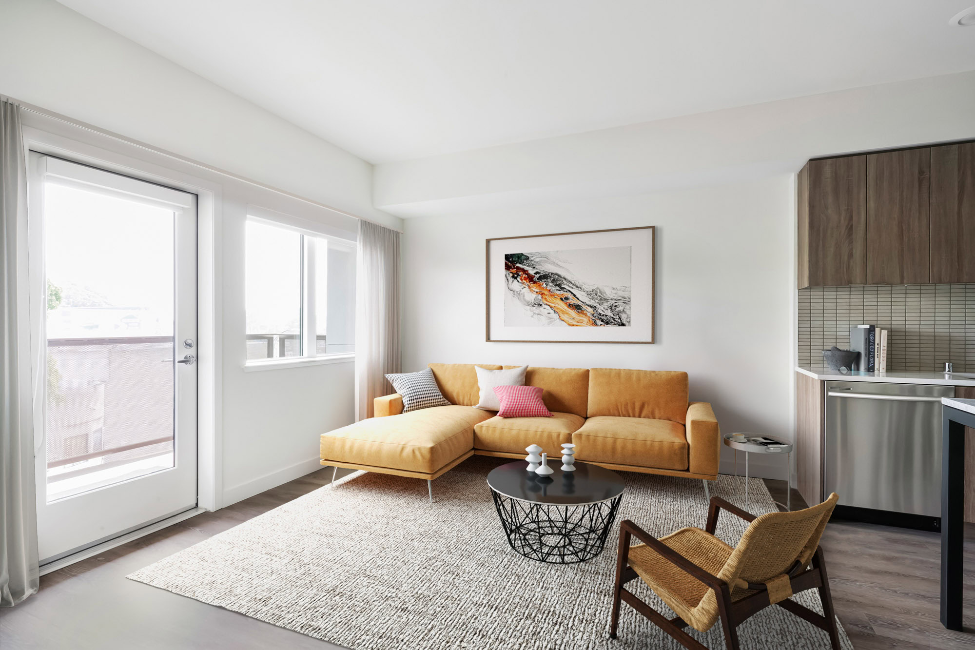 An open plan living room with a door to the balcony at a Webster Eleven apartment in downtown Oakland