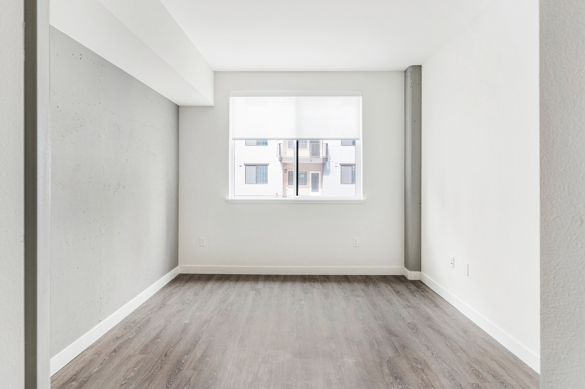 An open plan living room with a window at a Webster Eleven apartment in downtown Oakland