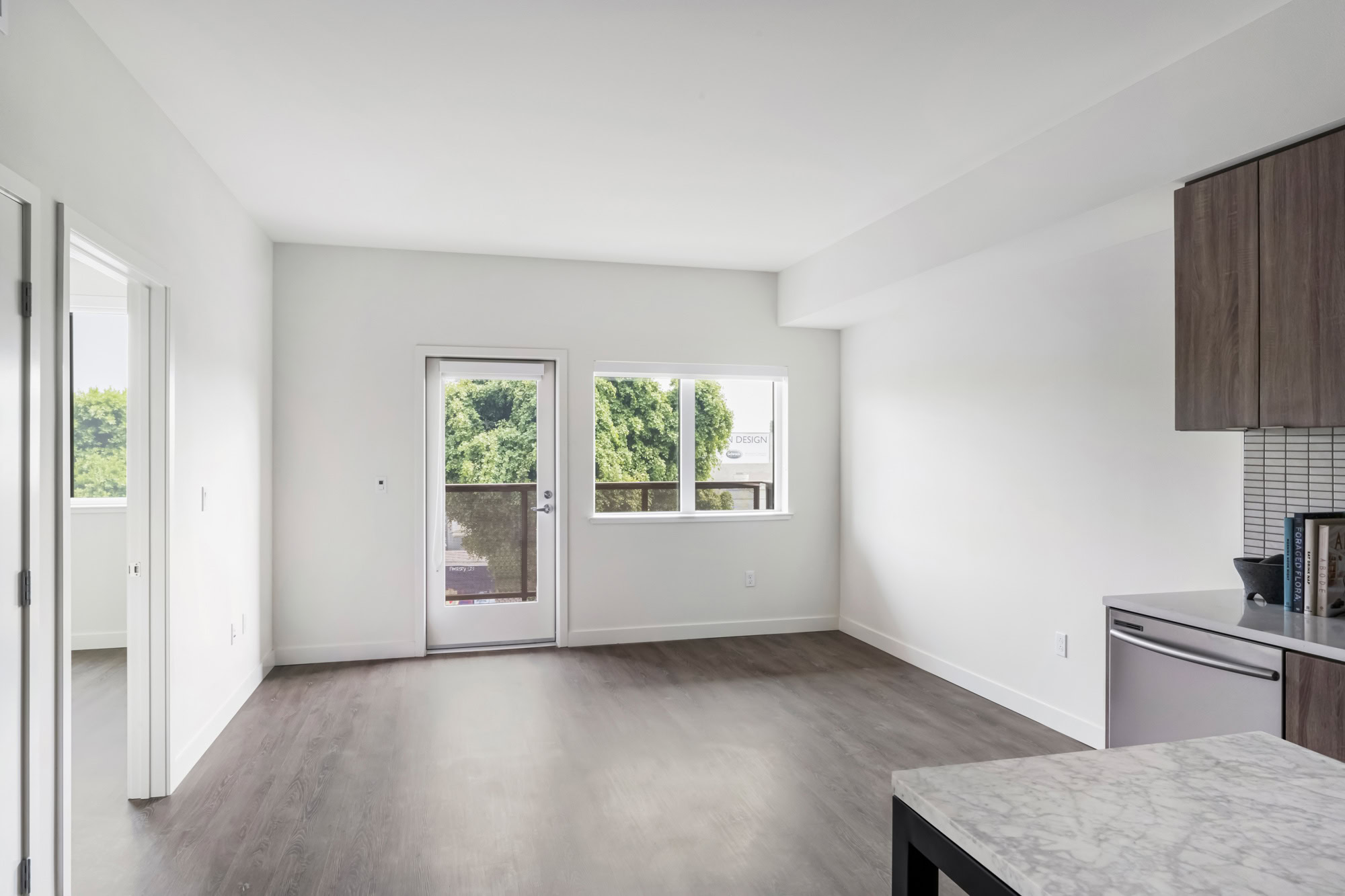 An open plan living room area with a door to a balcony at the Webster Eleven apartments in downtown Oakland for rent