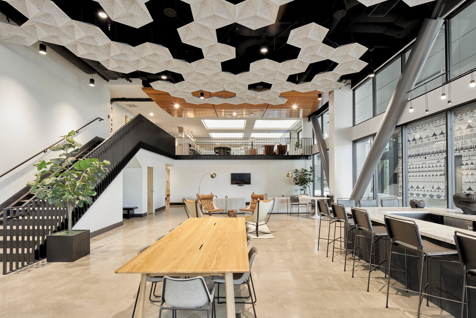 A coworking lounge with stairs leading to more space at The Logan luxury apartments in Oakland