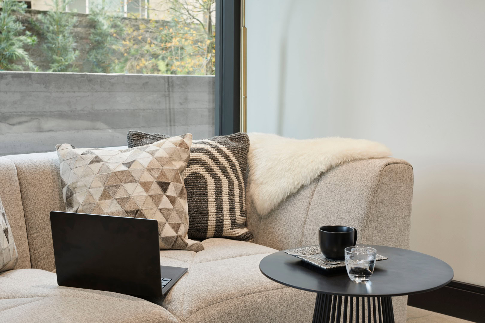 A cozy couch with a side table in a lounge at The Logan luxury apartments in Oakland CA