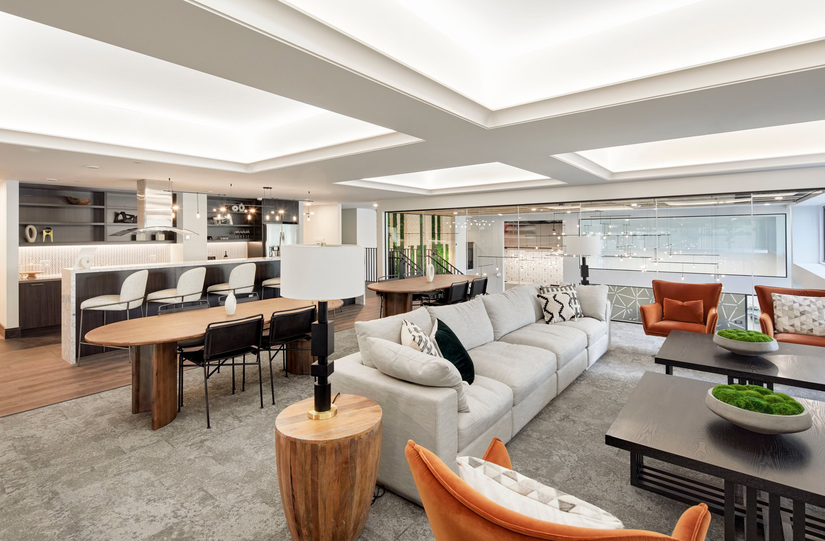 A lounge with a kitchen, dining area and lounge seating at the Logan luxury apartments in Oakland CA