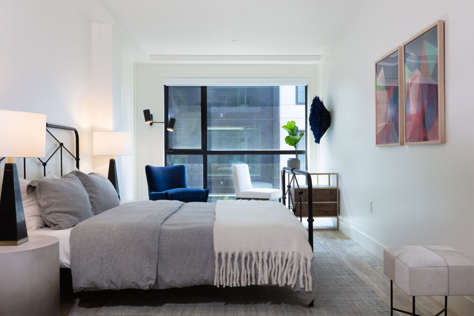 A spacious bedroom with black framed floor to ceiling windows at Temescal Oakland CA apartments, The Logan