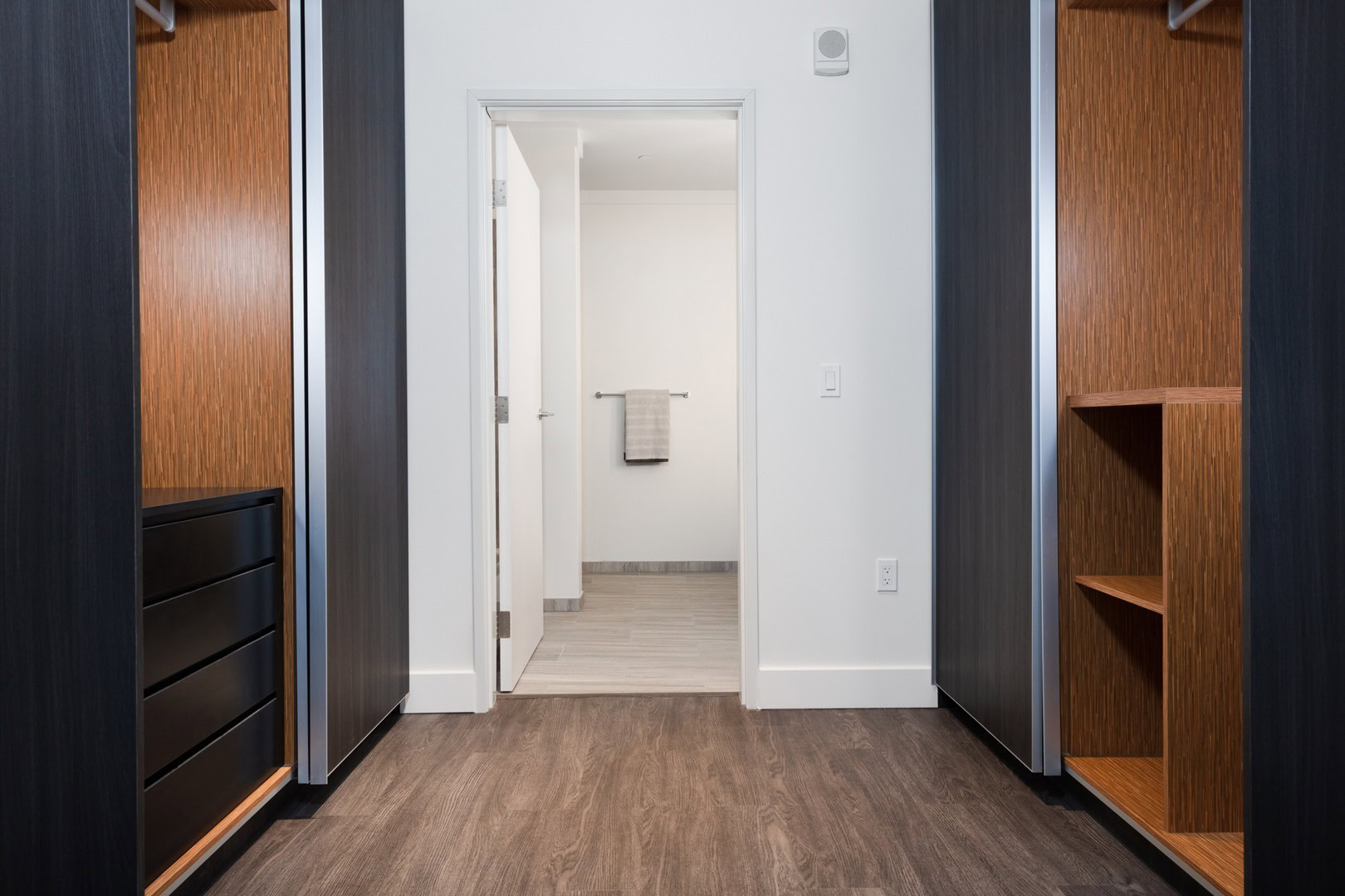 A spacious closet leading to a bathroom at The Logan apartments in Temescal