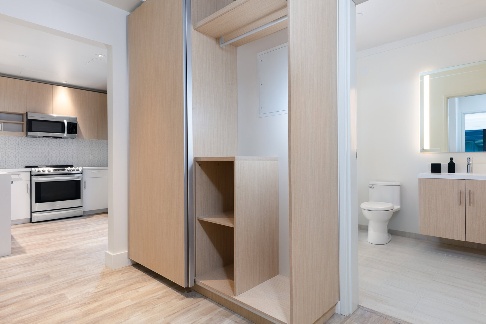 A closet space with storage space, next to a spacious bathroom at the oakland luxury apartments for rent, The Logan