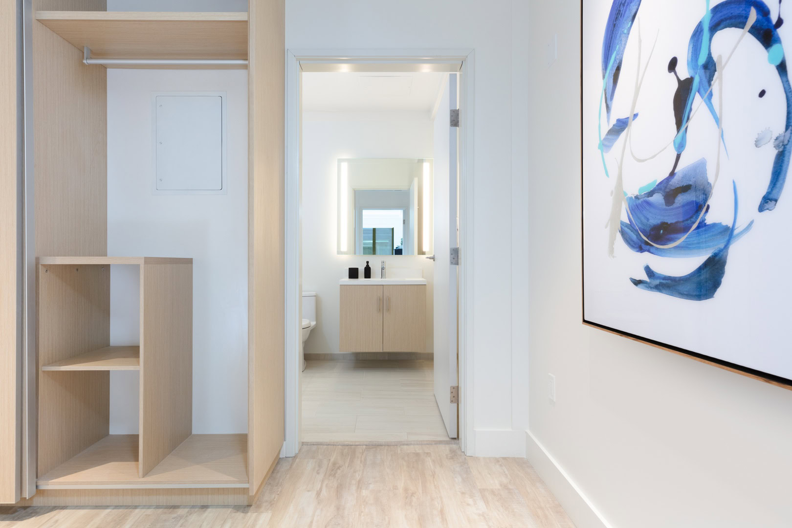 A closet right by the bathroom door in an apartment at the Oakland luxury apartments for rent, The logan