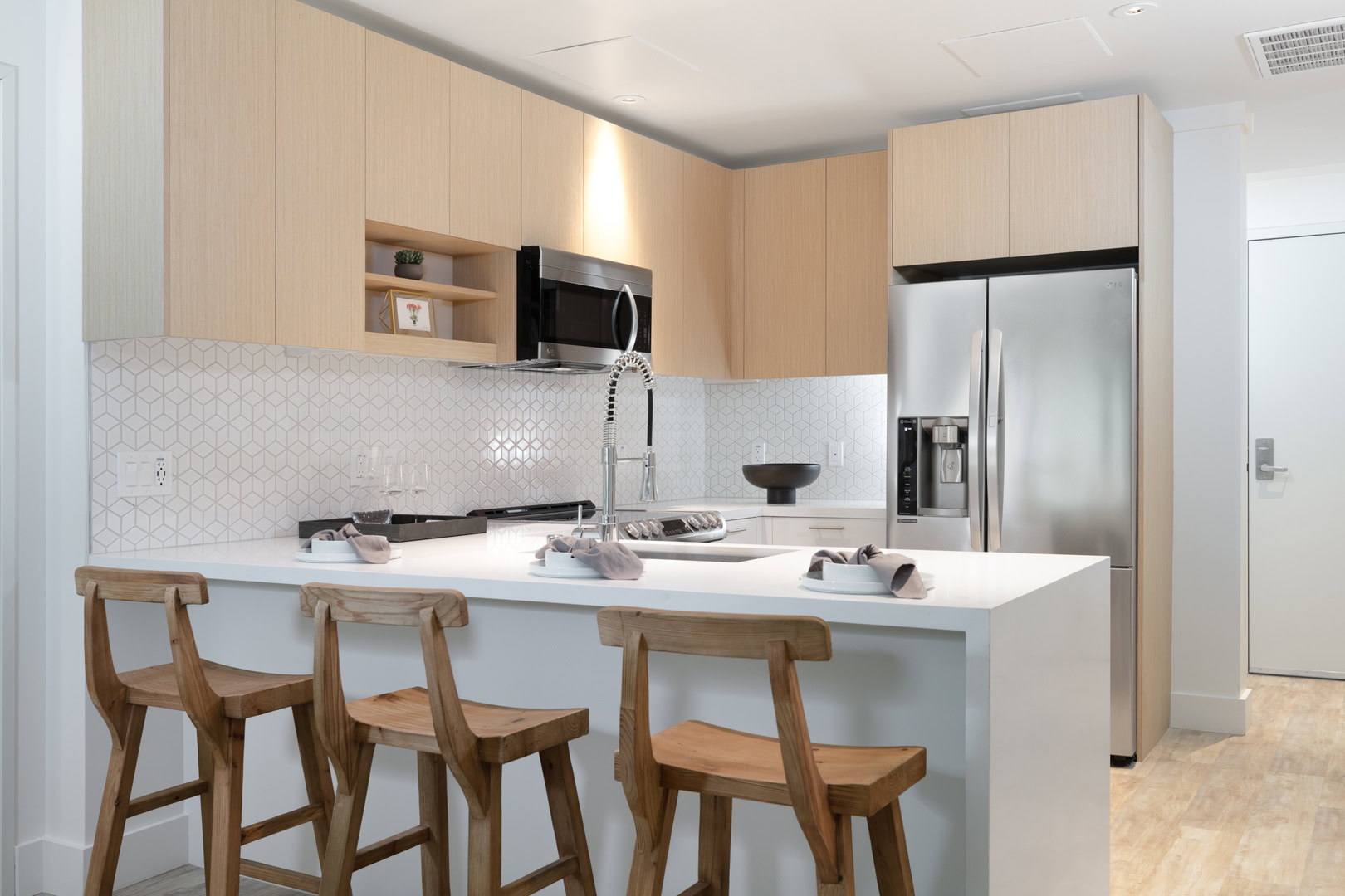 A modern kitchen with a peninsula for dining at the Logan apartment rentals in Oakland CA