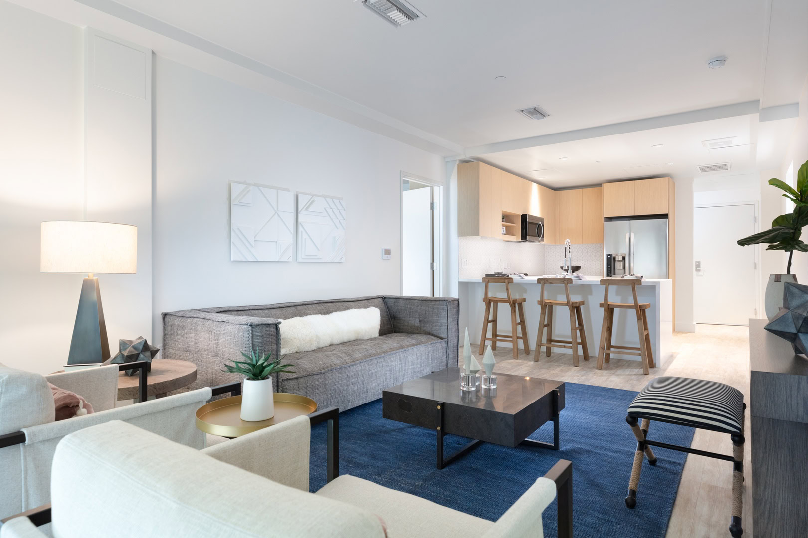 A spacious living room with modern furniture, facing the kitchen at the oakland luxury apartments for rent, The Logan