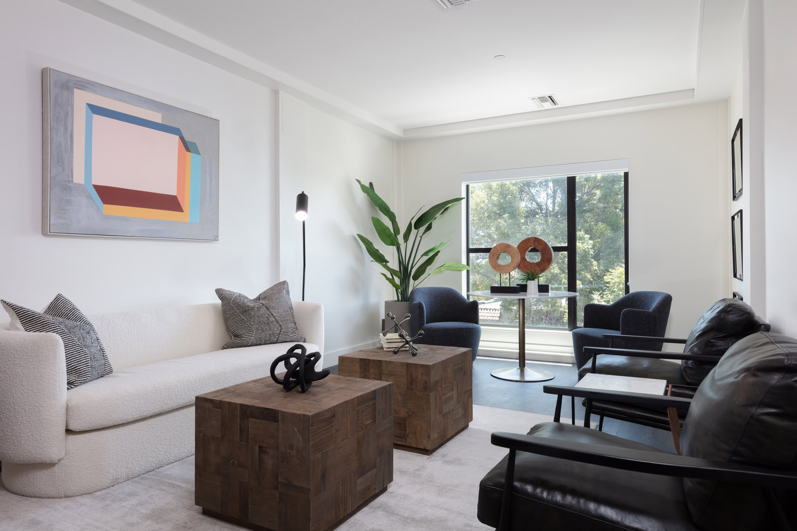 A spacious living room with a floor to ceiling window at The logan luxury apartments in Temescal Oakland, CA