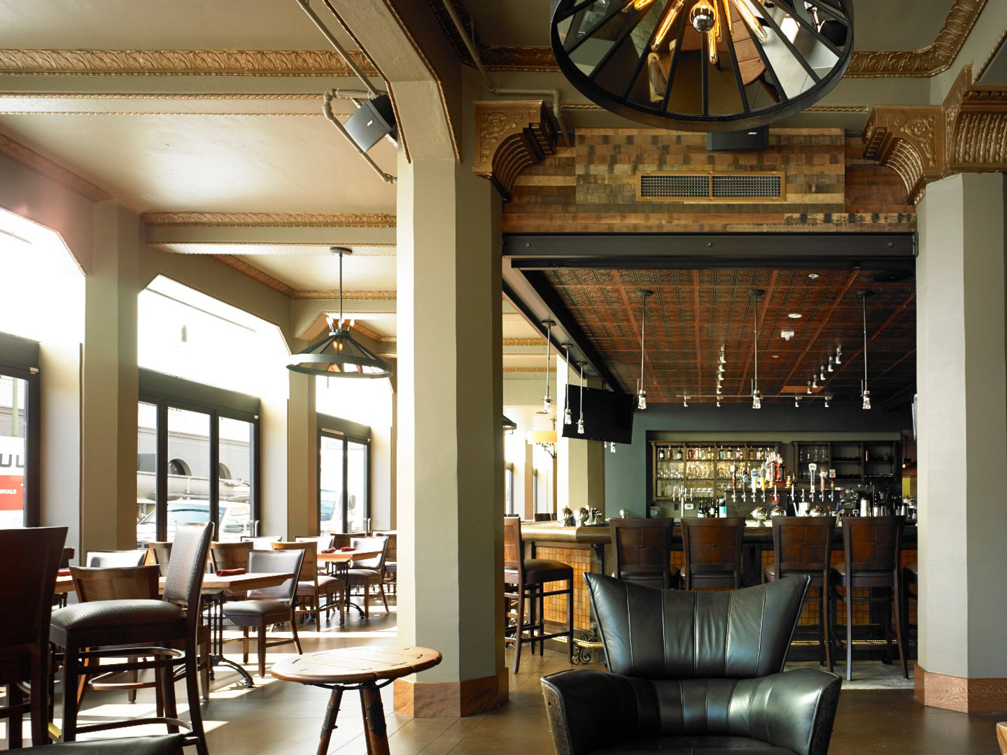 A mature bar and lounge with large windows against the wall in a neighborhood near The Logan, apartments in Temescal CA