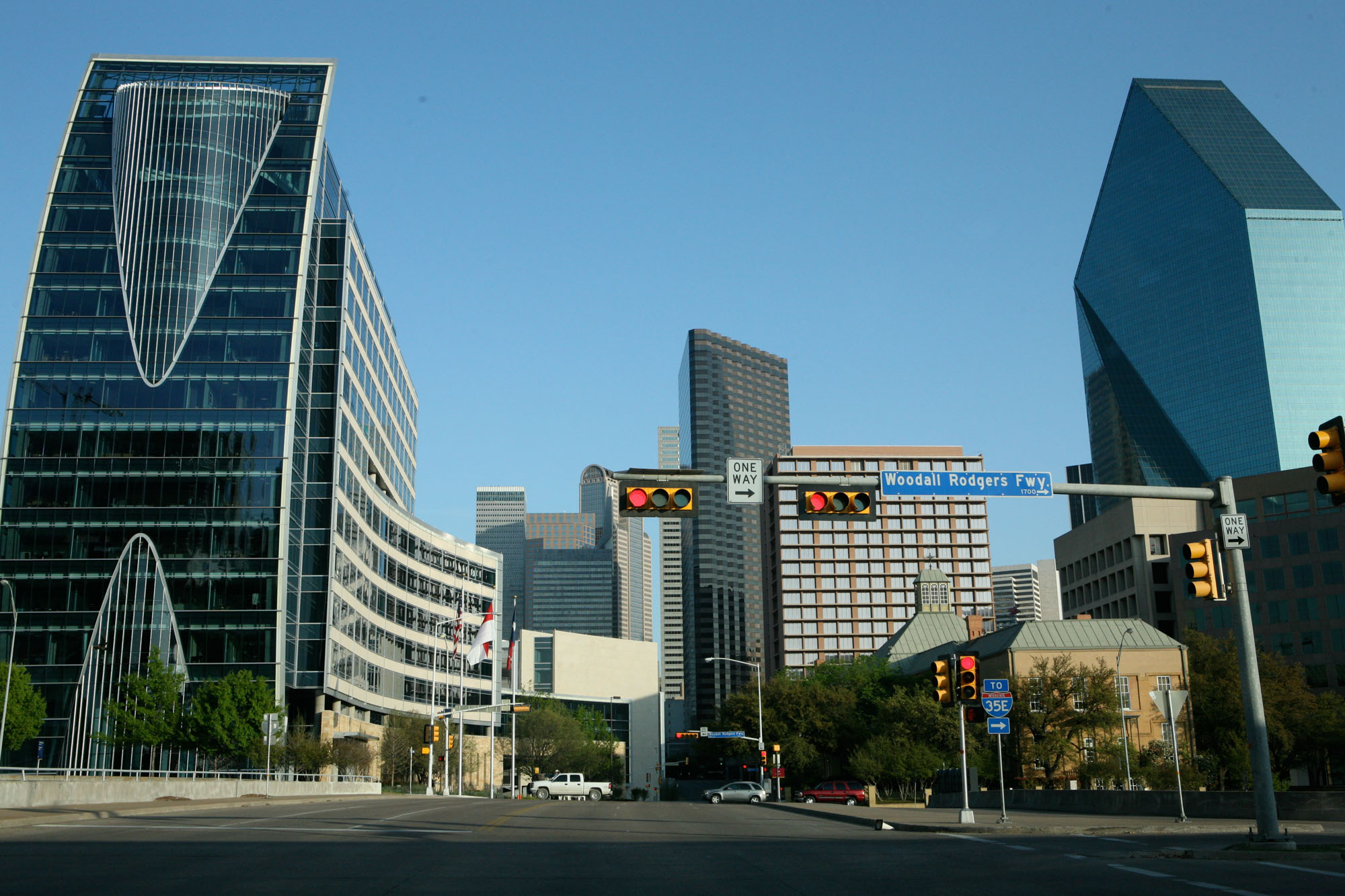 A street level view of the city near The Continental apartments in front of a stop sign with glass buildings and skyscrapers